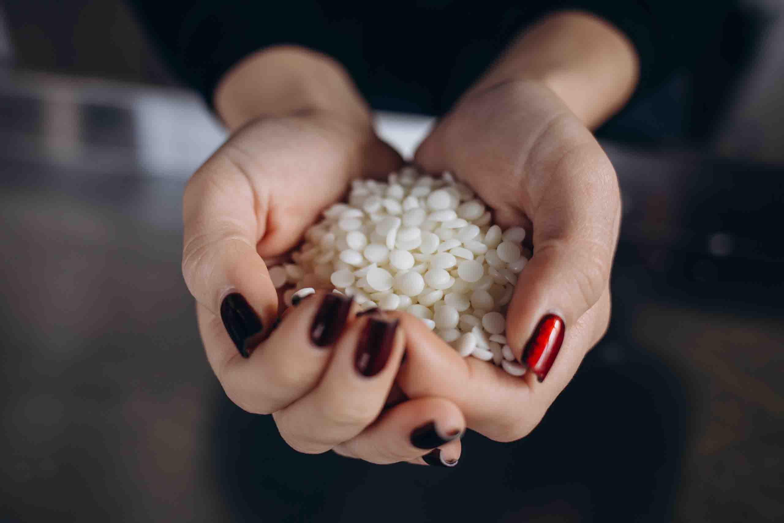 paraffin wax in women's hands in solid form before melted